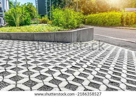 Environmentally friendly eco-paving - Concrete lawn grid with gravel filling for surface unsealing at residential house parking lot Royalty-Free Stock Photo #2186358527