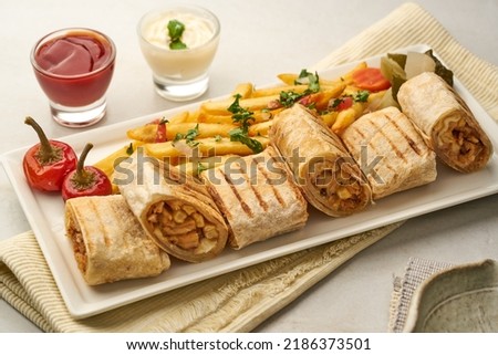 Arabic Shawarma with fries, ketchup, raita served in a dish isolated on grey background side view of fastfood Royalty-Free Stock Photo #2186373501