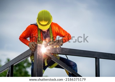 Asian Construction Workers Wearing Safety Gear go Through the Installation of a Structural link in an Industrial Factory. Royalty-Free Stock Photo #2186375179