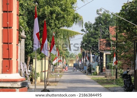 The red and white flag which is the Indonesian state flag flutters proudly on high poles during the celebration of Indonesia's independence day with a bright blue sky background. sense of patriotism