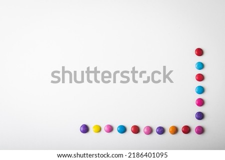 Overhead view of multi colored chocolate candies arranged by copy space over white background. unaltered, unhealthy eating and sweet food concept. Royalty-Free Stock Photo #2186401095