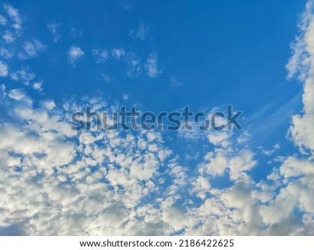 Beautiful cloudy sky. Blue sky with lots of white fluffy cumulus clouds, natural background, full frame. Selective focus.