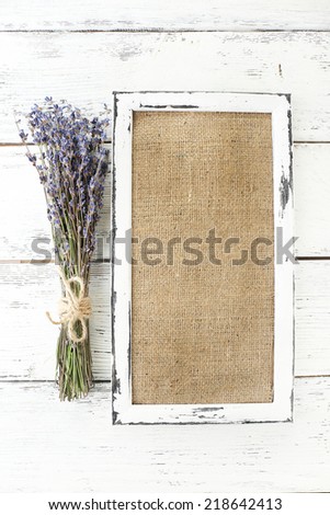 Lavender flowers and wooden frame on wooden background