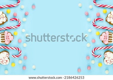 sweets, candies, cookies and lollipops on a blue background. Sweet Christmas Canes Top view copy space