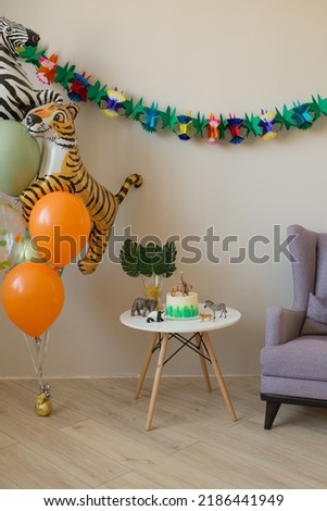Children's room decorated in honor of the birthday, safari style, animals, cake and balloons