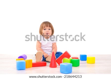 Little girl playing with colorful cubes