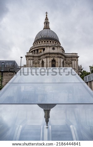 Reflection of the iconic dome and spire on top of St Pauls Cathedral in London reflecting on a glass roof above an escalator in London seen in July 2022.