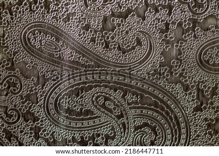 Texture of dark grey genuine leather close-up, with embossed floral trend pattern, wallpaper or banner design. With place for your text