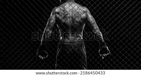 Black and white image of a man in a boxing cage. The concept of sports, Muay Thai, martial arts. Royalty-Free Stock Photo #2186450433