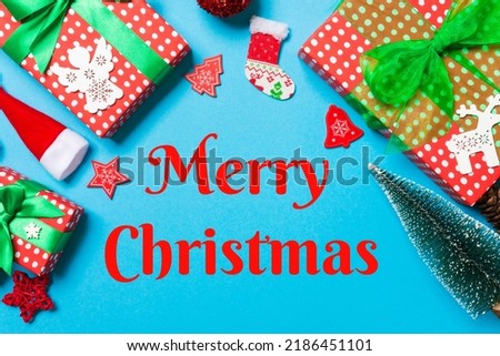Merry Christmas text. Top view of Christmas decorations on blue background. New Year holiday concept with copy space.