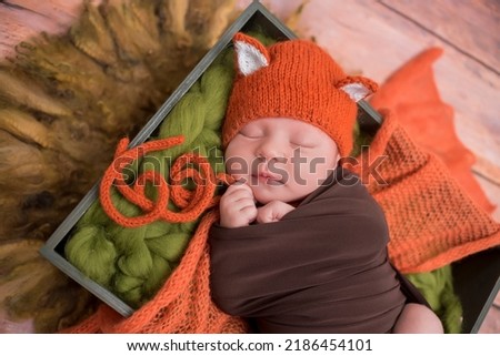 first photo shoot. newborn child. newborn. the child lies in orange cap. newborn girl