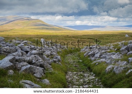 Whernside is a mountain in the Yorkshire Dales in Northern England. It is the highest of the Yorkshire Three Peaks, the other two being Ingleborough and Pen-y-ghent Royalty-Free Stock Photo #2186464431