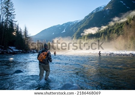 A man in wader walking through the river to get to a fly fishing spot Royalty-Free Stock Photo #2186468069