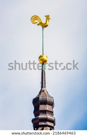 Symbol of old Riga town in Latvia - golden cockerel (rooster) topping bell tower of Riga Doms Cathedral. Royalty-Free Stock Photo #2186469463