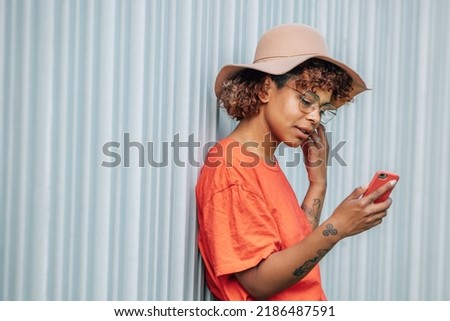 hipster girl with mobile phone and hat on the street