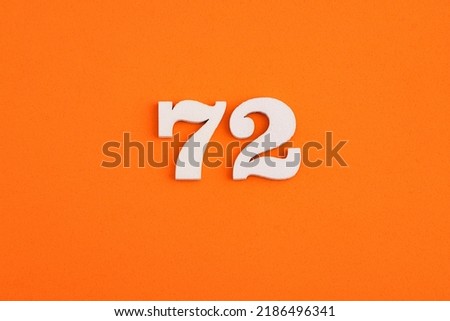 White wooden number 72 on eva rubber orange background Royalty-Free Stock Photo #2186496341