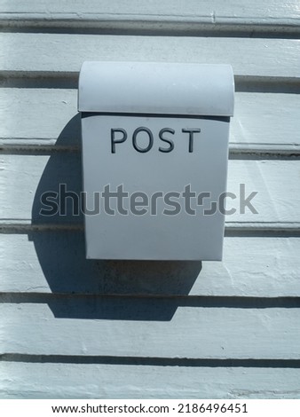 white mailbox with white wall in the background