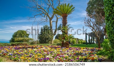 Landscape of colourful flowers and palm trees on the Amalfi coast of Ravello Italy with bright sun and blue sky