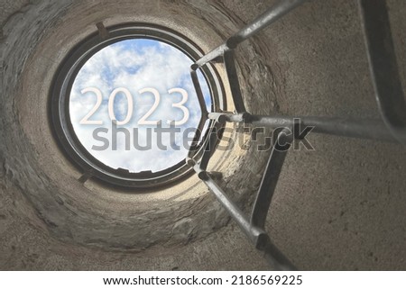 the ladder up from the deep well, the concept of 2023, the new year of 2023, the concept of the future and success against the blue sky, tinting, selective focusing