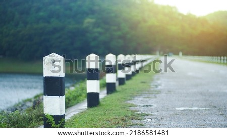 Traffic road pole (Road blocking pillar) Concept of transportation and marking. Shallow depth of field. Orange light landscape shining through mountains and nature