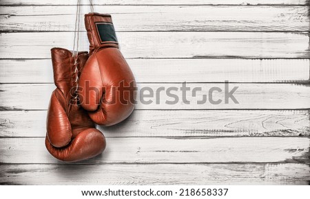 Boxing gloves hanging on wooden wall Royalty-Free Stock Photo #218658337