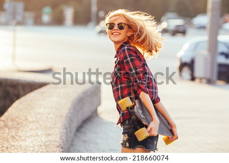 Sport fashion girl posing in summer with skateboard Royalty-Free Stock Photo #218660074