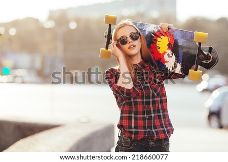 Sport fashion girl posing in summer with skateboard  Royalty-Free Stock Photo #218660077