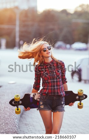 Sport fashion girl posing in summer with skateboard Royalty-Free Stock Photo #218660107