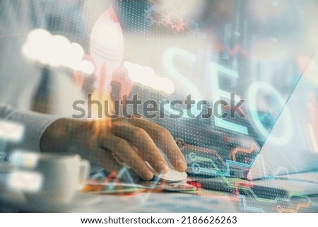 Double exposure of seo icon with man working on computer on background. Concept of search engine optimization.