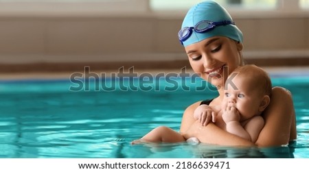 Swimming coach with funny baby in pool