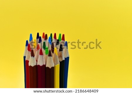 Colored pencils for drawing are depicted on a yellow background. The pencils are sharpened. A great set for drawing.