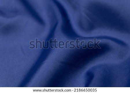 Mauled navy-colored fabric texture background. This fabric is made of 100% polyester. Royalty-Free Stock Photo #2186650035