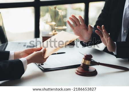 Individuals are giving bribes to officials in order to commit corruption in lawsuits, illegal actions by law enforcement by paying bribes to officials are illegal and unlawful. Fraud concept. Royalty-Free Stock Photo #2186653827