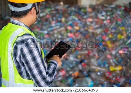 A recycling Analyst looking at plastic bottle ofr recycling waste To proceed to the next process. 