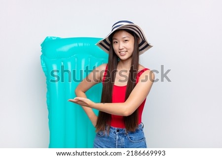 asian young woman feeling happy and cheerful, smiling and welcoming you, inviting you in with a friendly gesture. summer concept