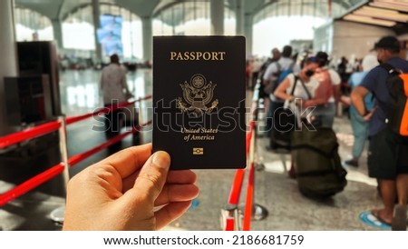 Holding Blue American Passport at the International Airport. Touirists are at Blurred Background. Royalty-Free Stock Photo #2186681759
