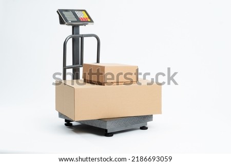 Industrial scale for weighing parcels for shipping with adhesive tape for packaging. Industrial scale isolated on white background. Royalty-Free Stock Photo #2186693059
