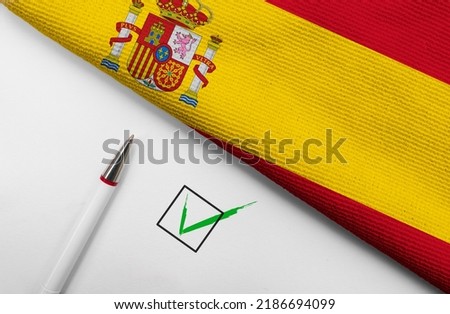 Pencil, Flag of Spain and check mark on paper sheet  Royalty-Free Stock Photo #2186694099