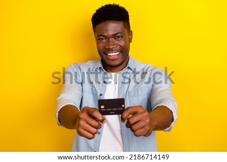 Photo of positive guy hold credit card recommend banking service for earnings salary isolated bright color background