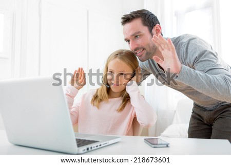 Father and daughter video calling on a laptop Royalty-Free Stock Photo #218673601