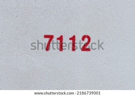 Red Number 7112 on the white wall. Spray paint.
