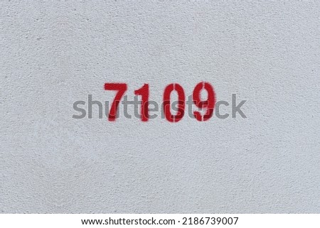 Red Number 7109 on the white wall. Spray paint.
