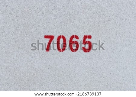 Red Number 7065 on the white wall. Spray paint.
