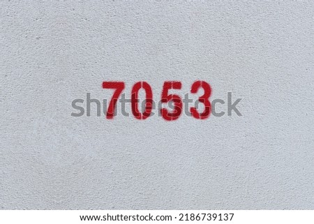 Red Number 7053 on the white wall. Spray paint.
