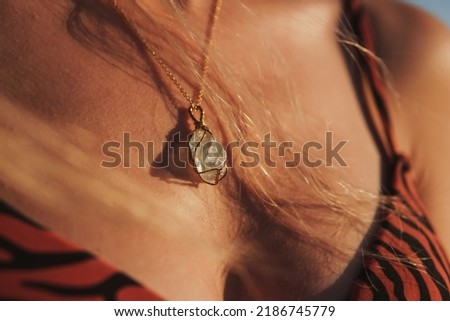 Natural stone necklace on young woman's neck, natural stone necklace,  in the sunlight, selective focus