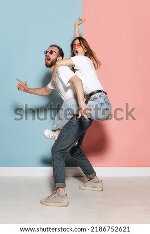 Diversity. Young crazy man and astonished girl having fun isolated on blue and pink trendy color background. Human emotions, youth, love and lifestyle concept