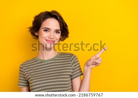 Portrait of young pretty woman smiling directly pointing empty space new advertisement isolated on bright yellow color background