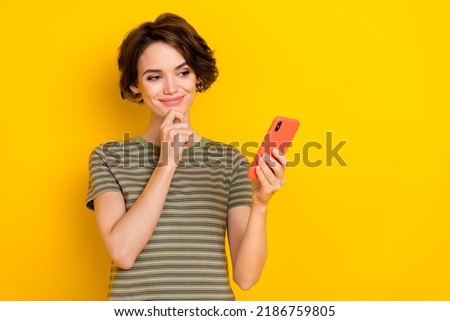 Photo of dreamy pretty lady wear striped t-shirt arm chin reading modern device empty space isolated yellow color background