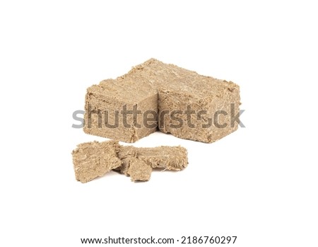 Sunflower halva on a white background crumbled and in pieces. Copy space.