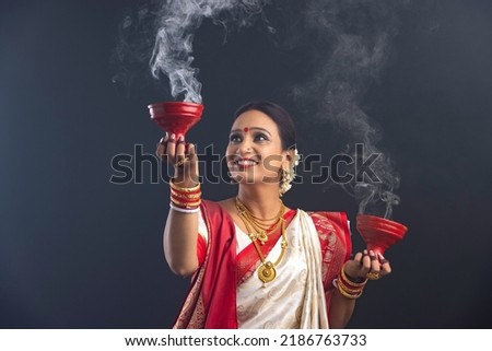 Portrait of Bengali woman holding a dhunuchi Royalty-Free Stock Photo #2186763733